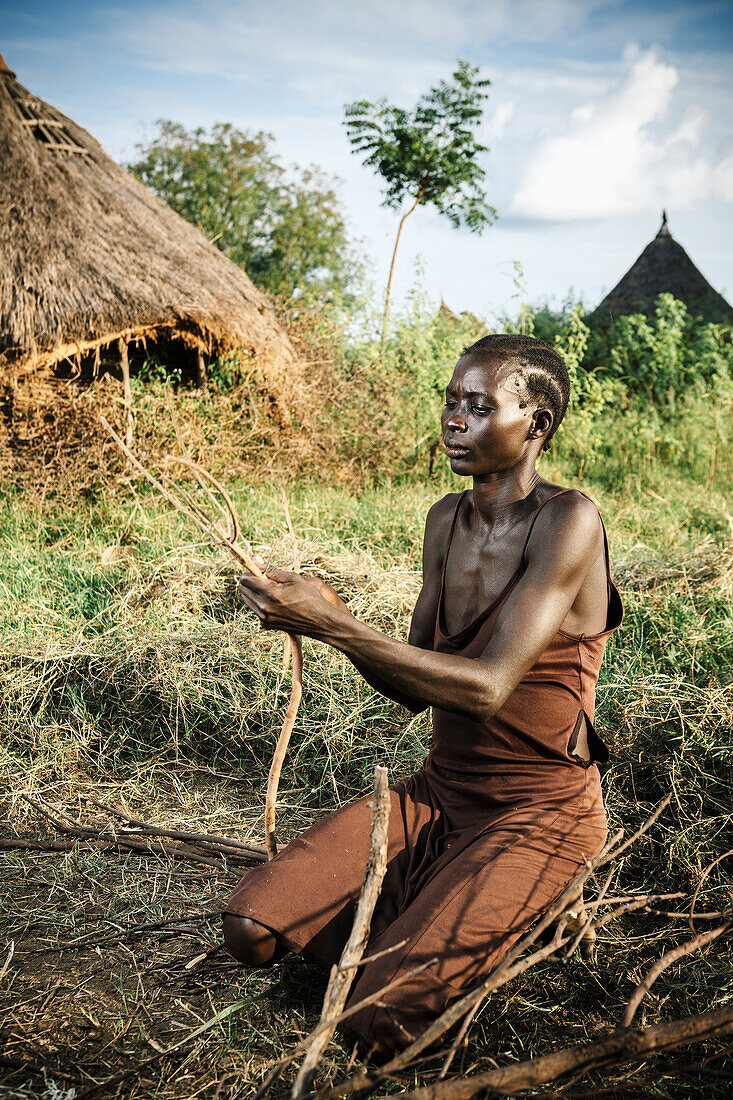 'Nuer woman preparing firewood, near Gambella, Western Ethiopia; Ethiopia'