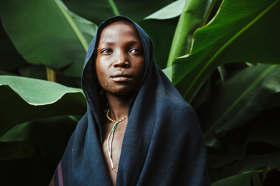 'Young Suri boy under banana tree, Omo region, Southwest Ethiopia; Kibish, Ethiopia'