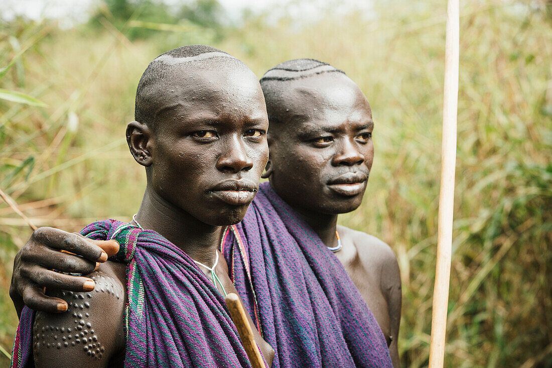 'Young Suri (Surma) men in village of Kibish, Omo region, Southwest Ethiopia; Kibish, Ethiopia'