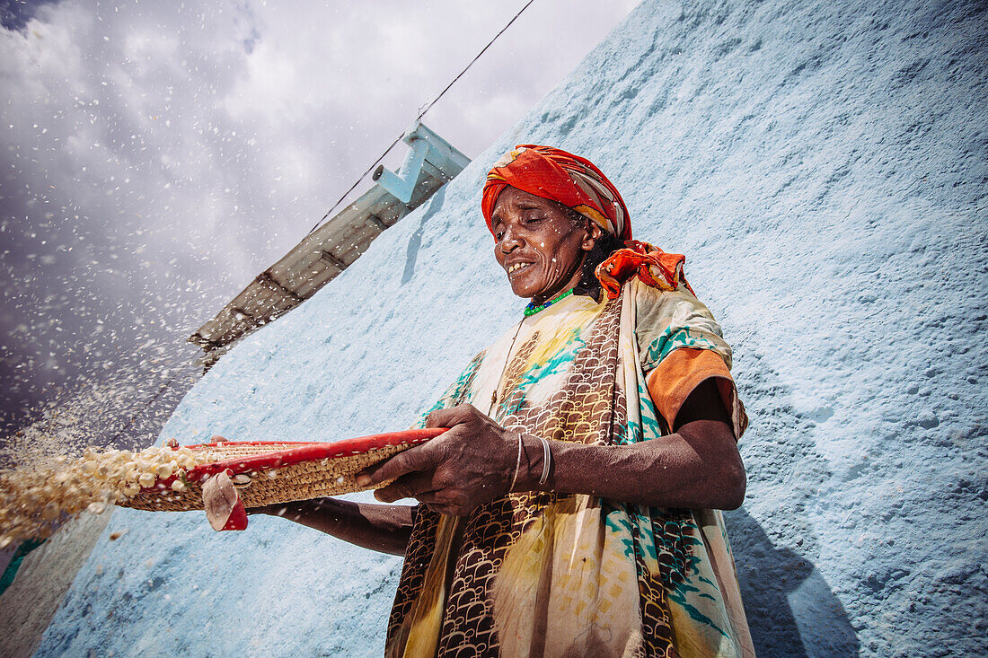 'A woman winnowing grain in the back streets; Harar, Ethiopia'