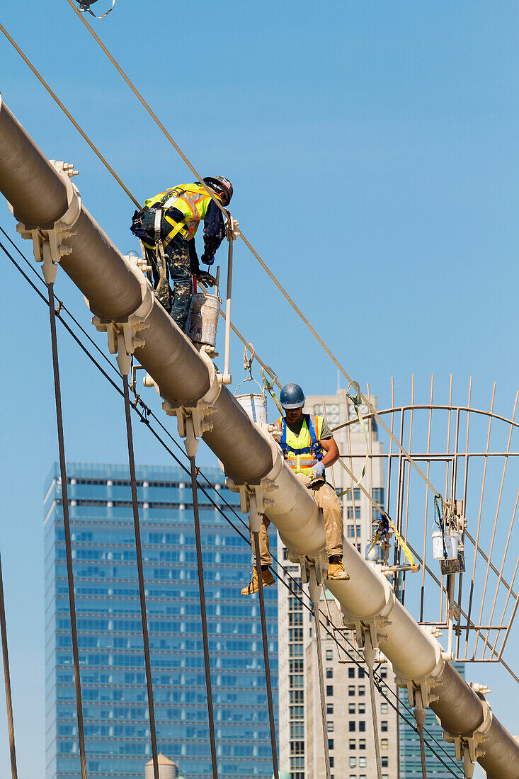 Men painting a suspension cable of the Brooklyn Bridge, New York City, New York, United States