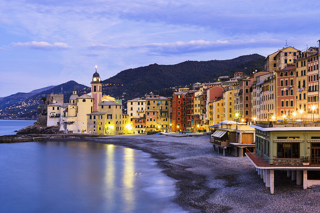 'Buildings illuminated by lights along the water's edge at sunrise; Camogli, Liguria, Italy'