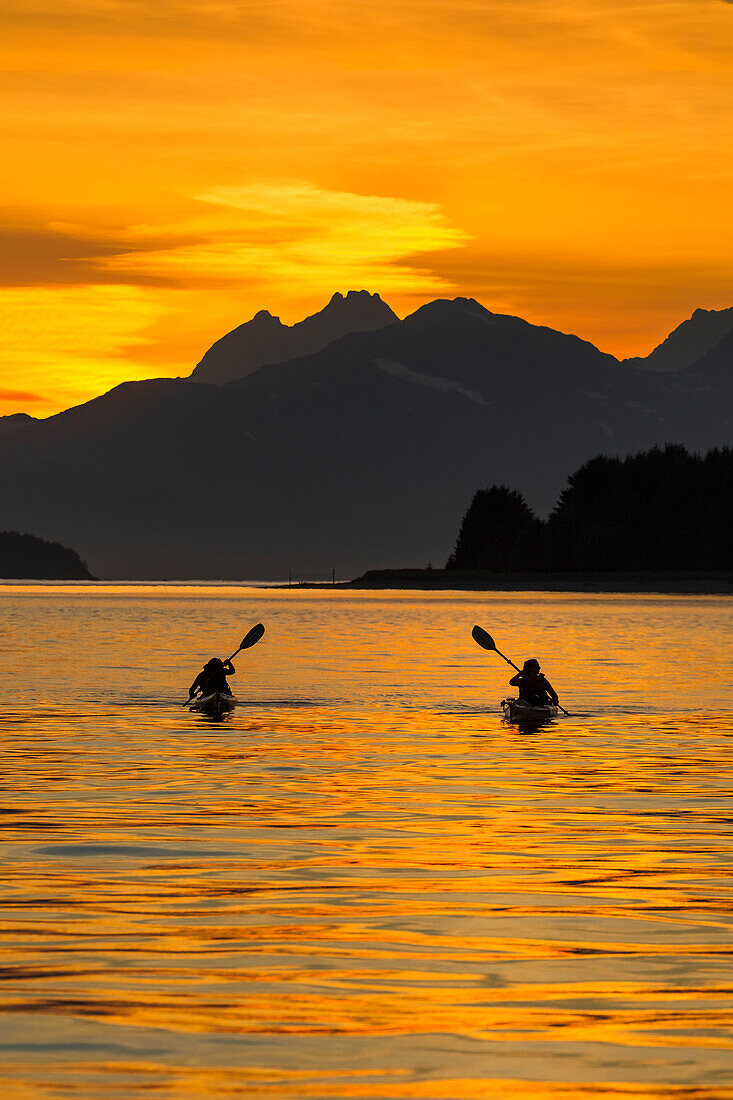 Sea Kayaking on a sublime evening in Lynn Canal near Eagle Beach State Recreation Area, Juneau. Alaska. Chilkat Mountains beyond in the distance.