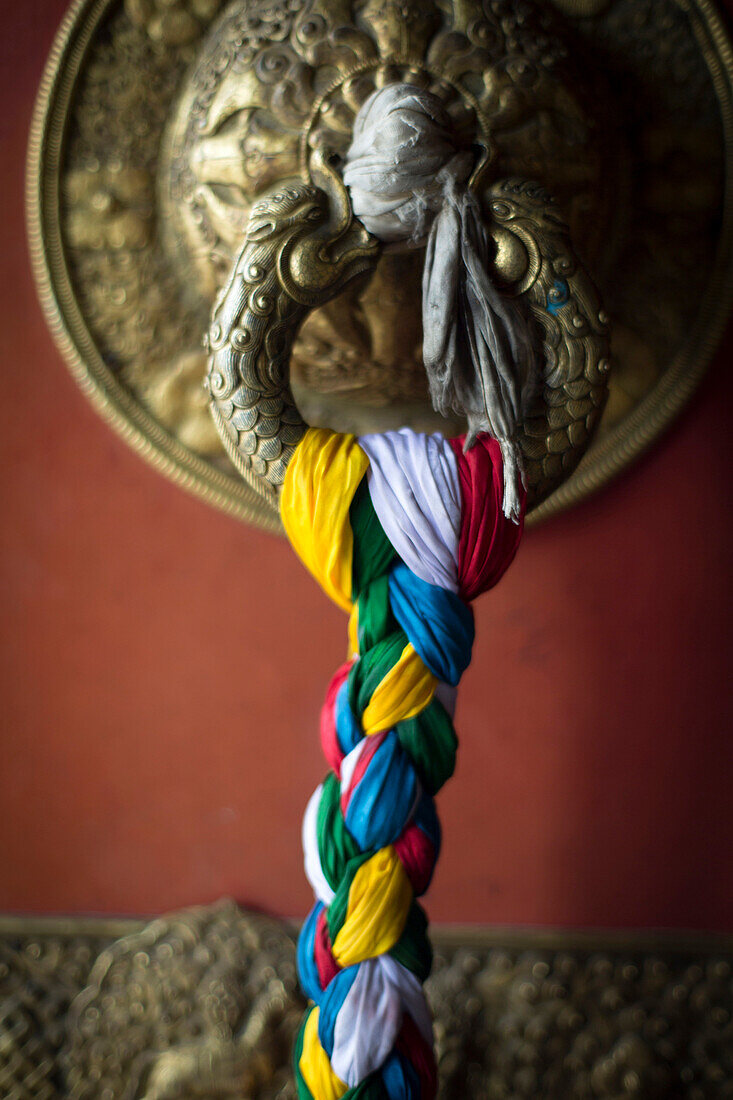 A colorful braided cloth adorns the door of the Swayambu Temple complex in Kathmandu, Nepal