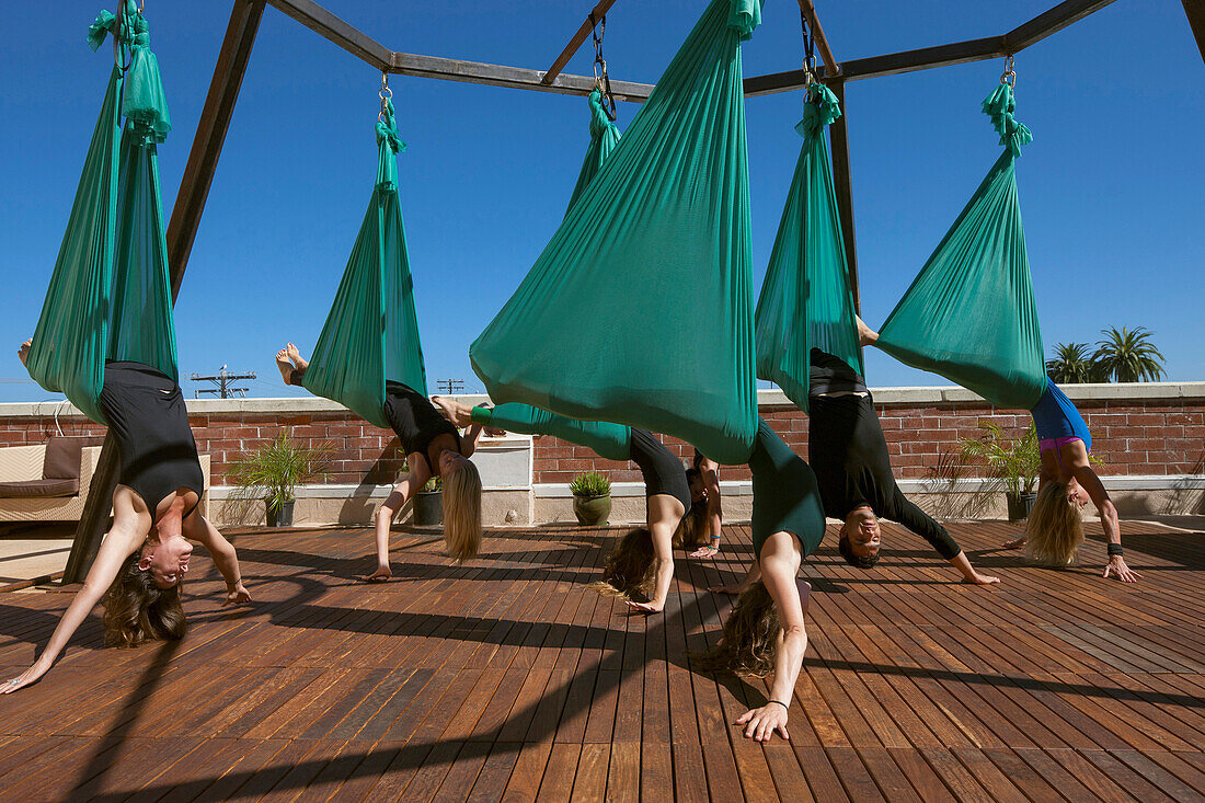 A group performs aerial yoga in San Diego California.