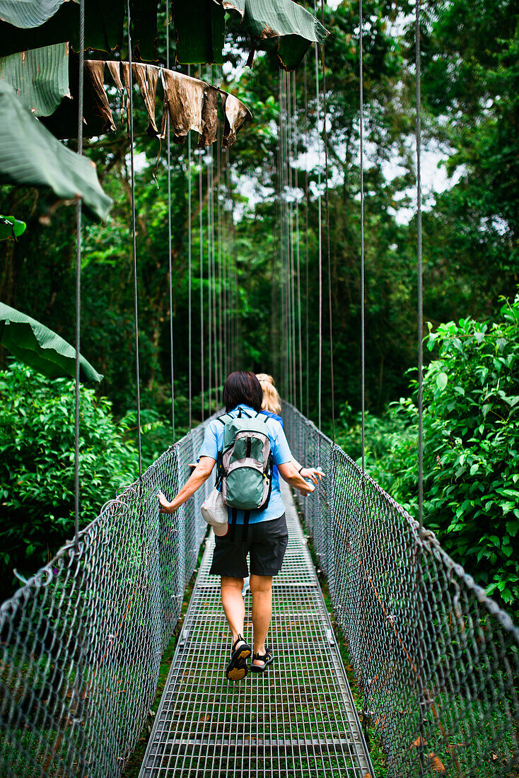 Two women walk on a hanging Bridge