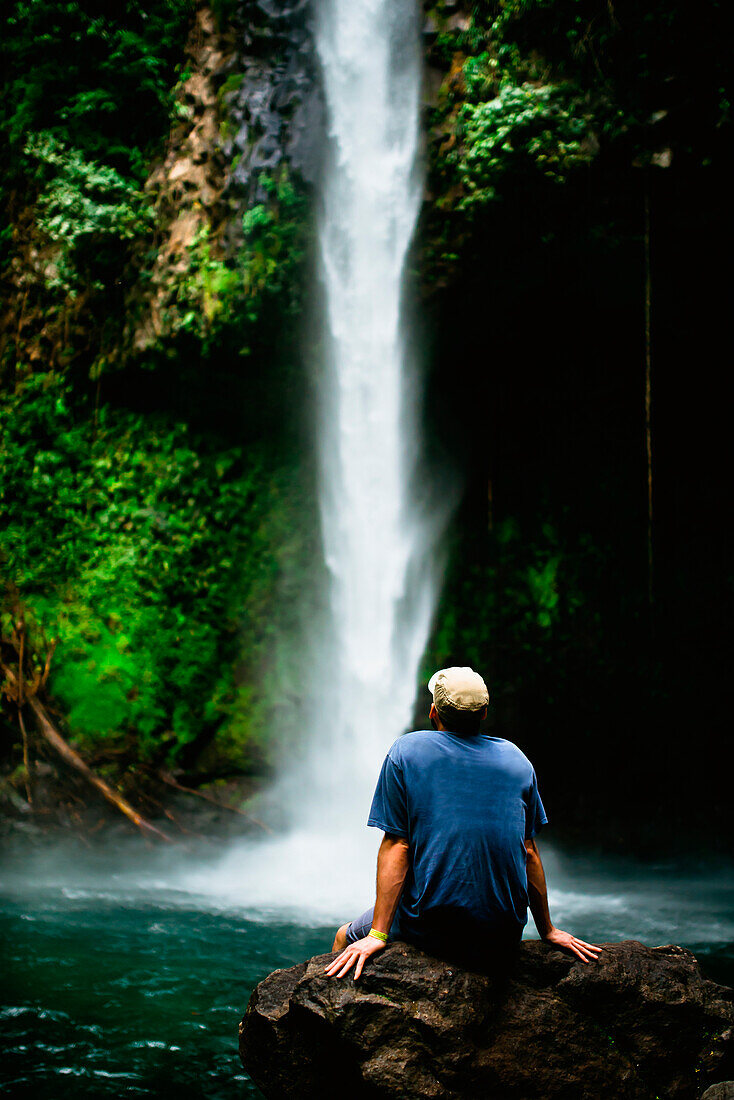 A man watches a waterfall