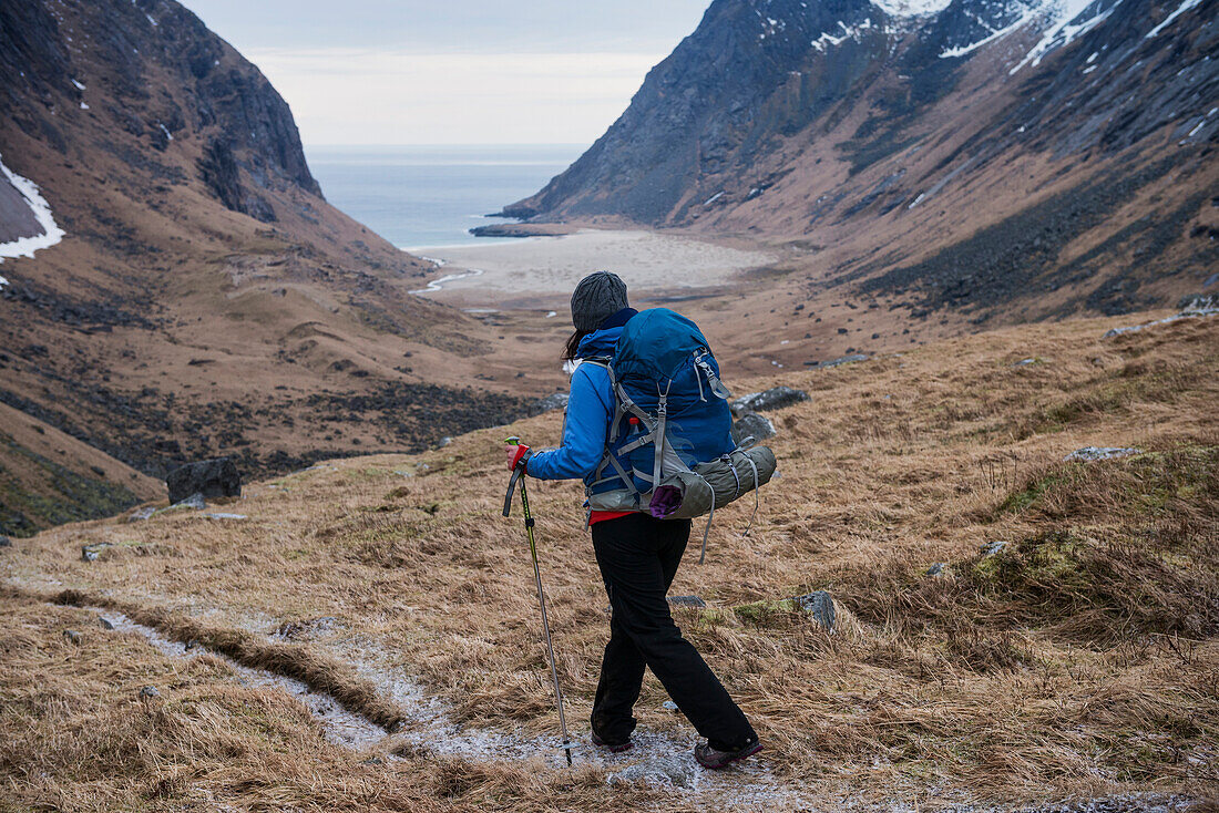 Female hiker hiking trail towards Horseid beach, Moskenes??y, Lofoten Islands, Norway