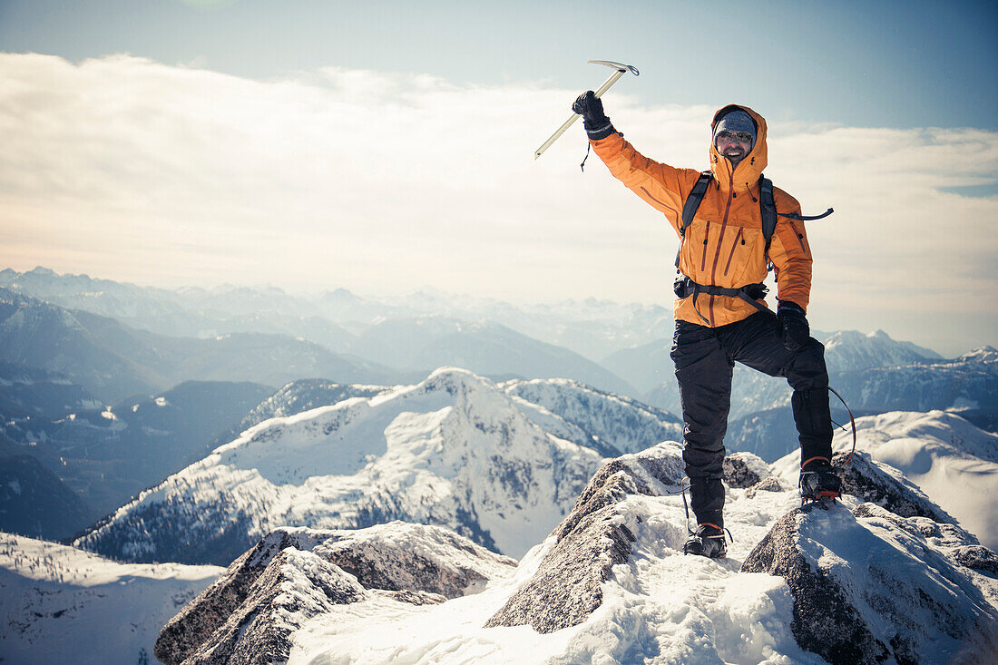 Climber on mountain summit in the Coquihalla Recreation Area of British Columbia, Canada.