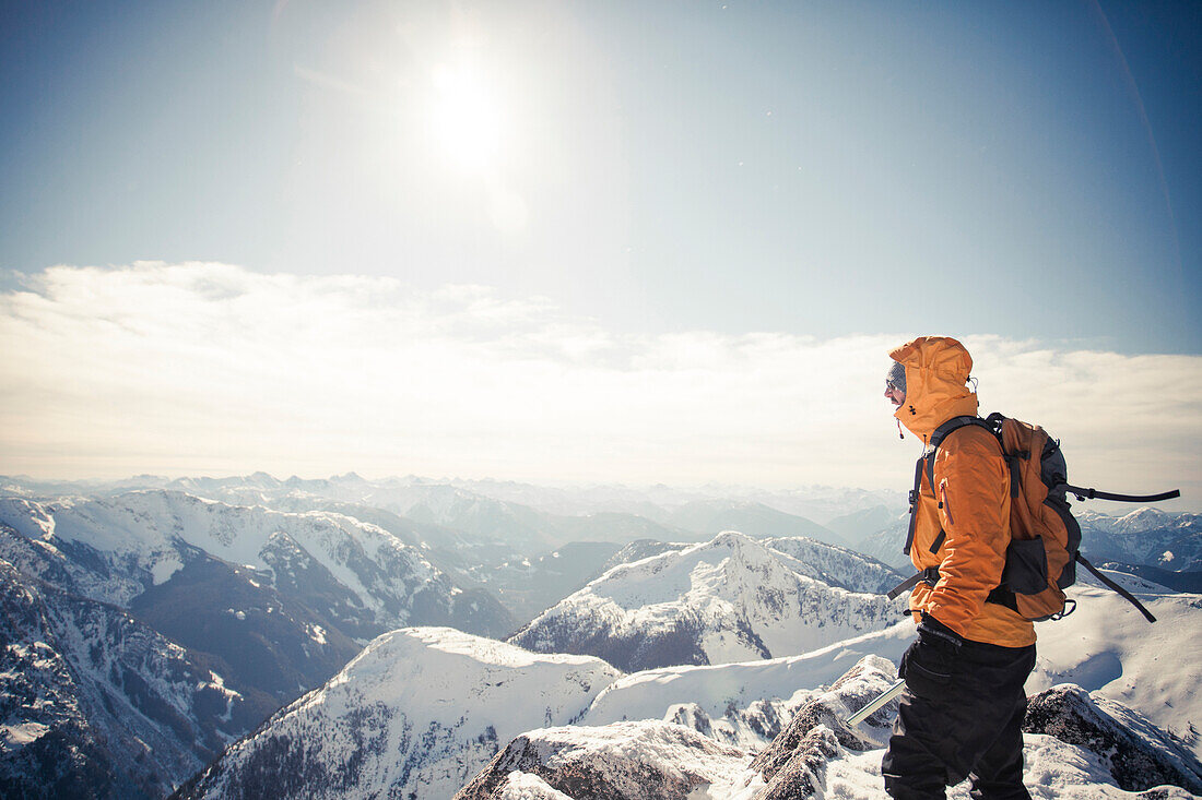A mountaineer take in the view from a mountain summit in the Coquihalla Recreation Area of British Columbia, Canada.