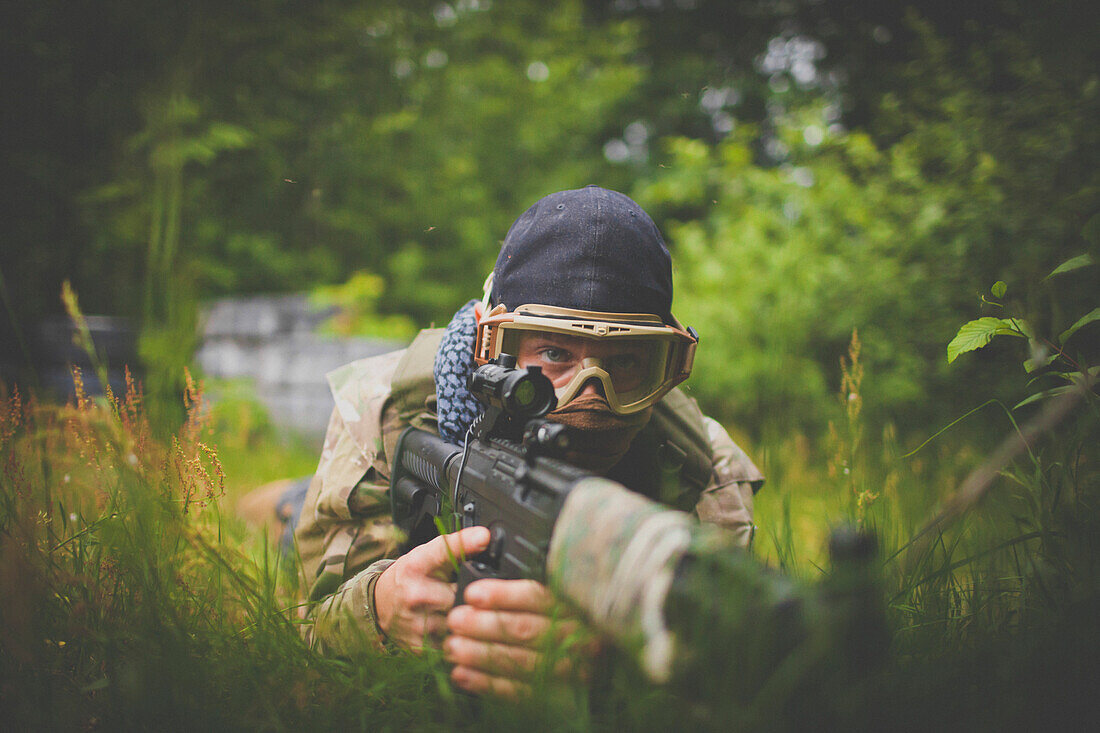 A soldier hides out in thick grass to get a better vantage point during a gun battle.