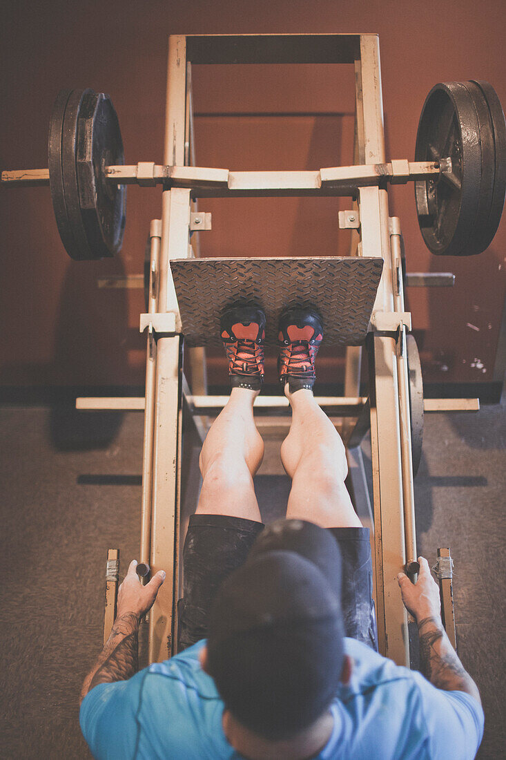 Adam Palmer, a mountain athlete, works out on the leg press at the gym.