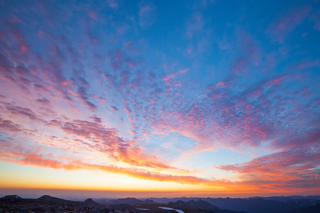 The sun illuminates the sky above Burroughs Mountain just before sunrise.