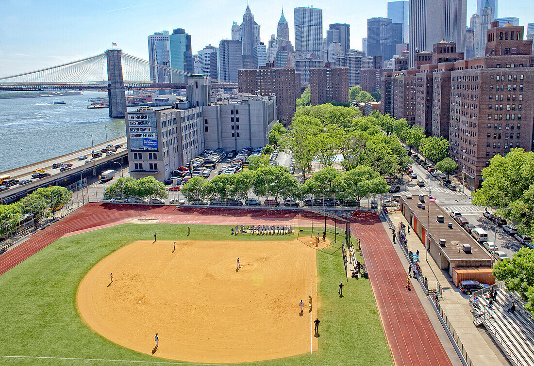 Aerial view of Brooklyn Bridge and a ball diamond on the East River in New York City, New York, United States of America.