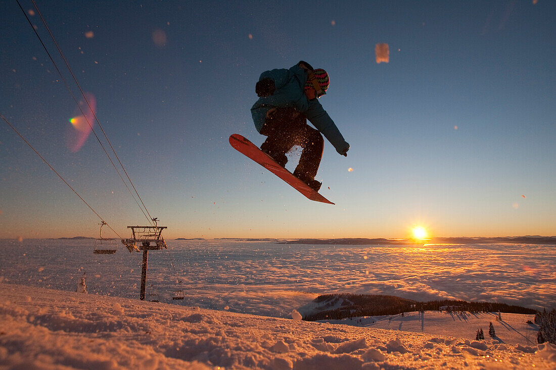 Snowboarder jumping at sunset in Whitefish, Montana.