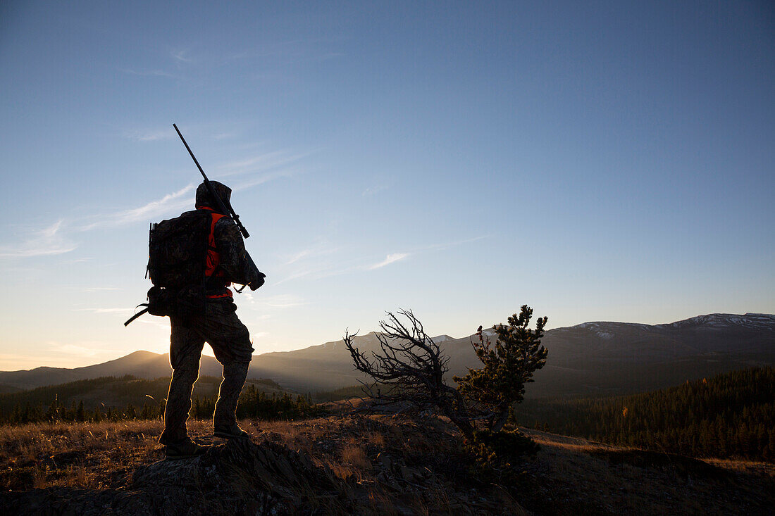 A backlit male hunter at sunrise.