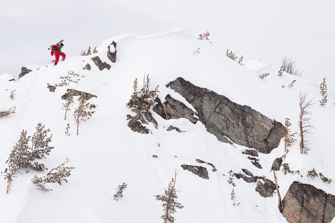 A male backcountry skier boot packs up a steep ridge to ski a line in the Beehive Basin near Big Sky, Montana.