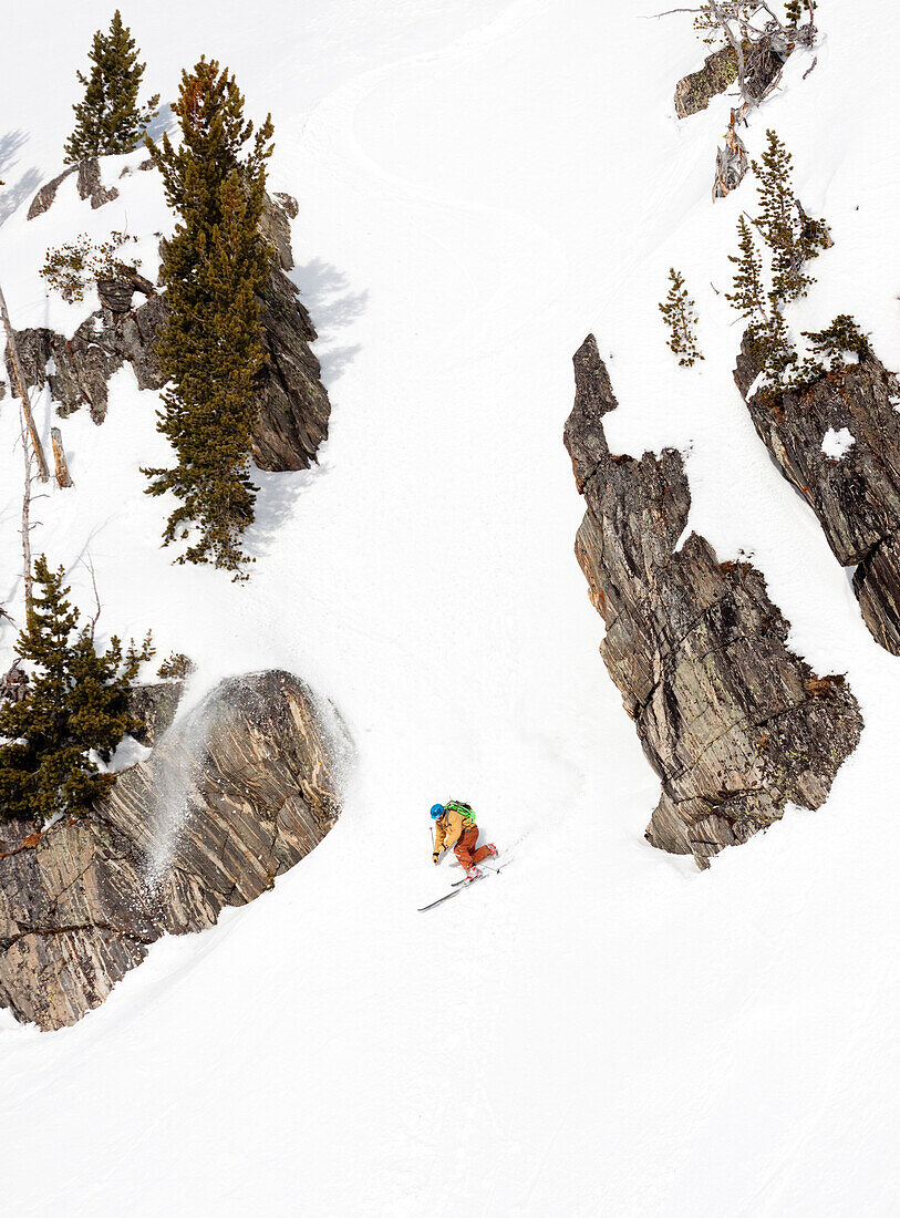 A male backcountry skier with a backpack on makes a powder turn in the Beehive Basin near Big Sky, Montana.