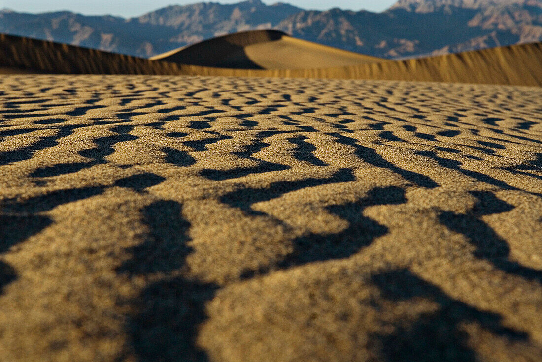 Sand patterns lead up to a giant dune at Mesquite Flat Sand Dunes in Death Valley National Park, California.