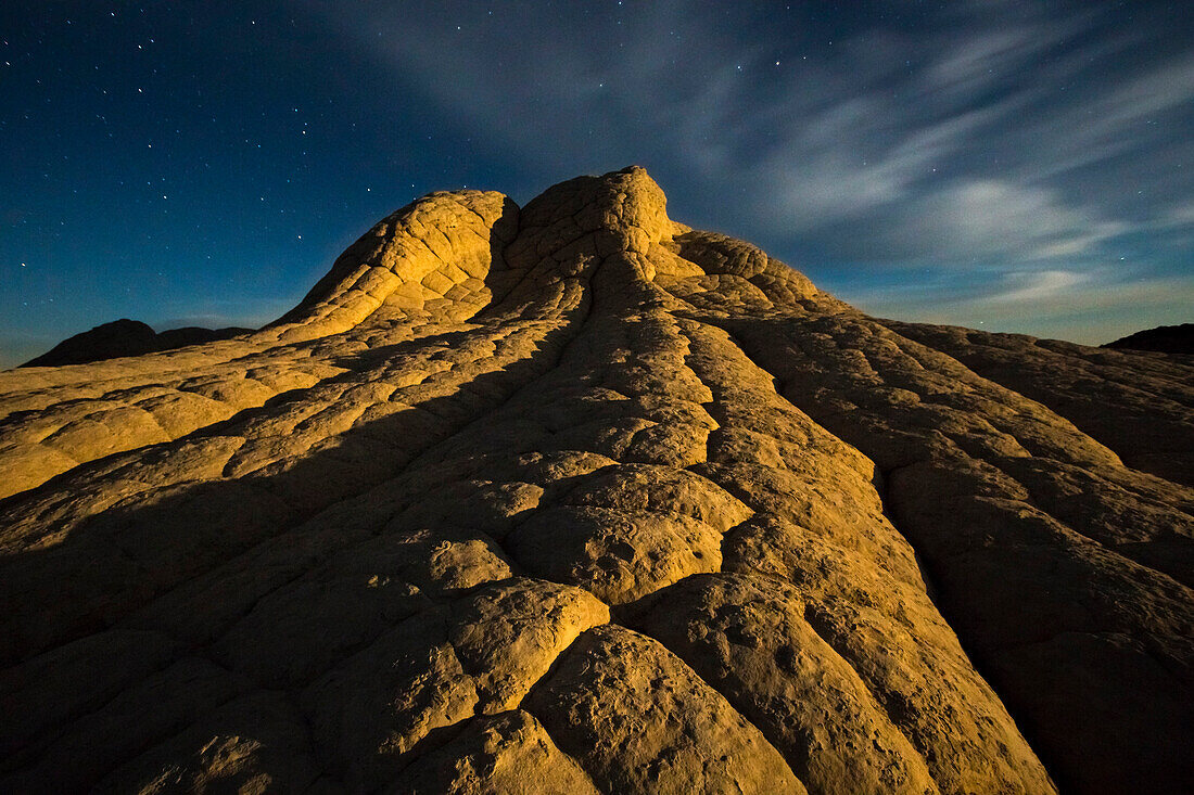 Sandstone formations illuminated by the rising moon in Arizona's White Pocket.