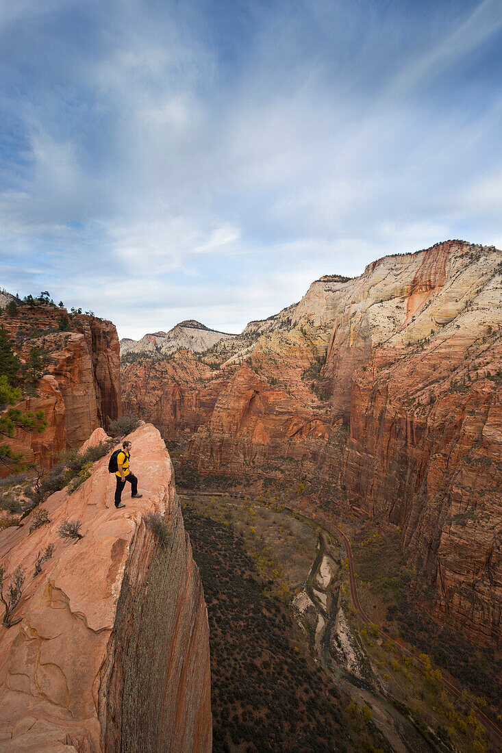 A hiker stands on a cliff along the popular Angels Landing trail in Zion National Park near Springdal Utah.