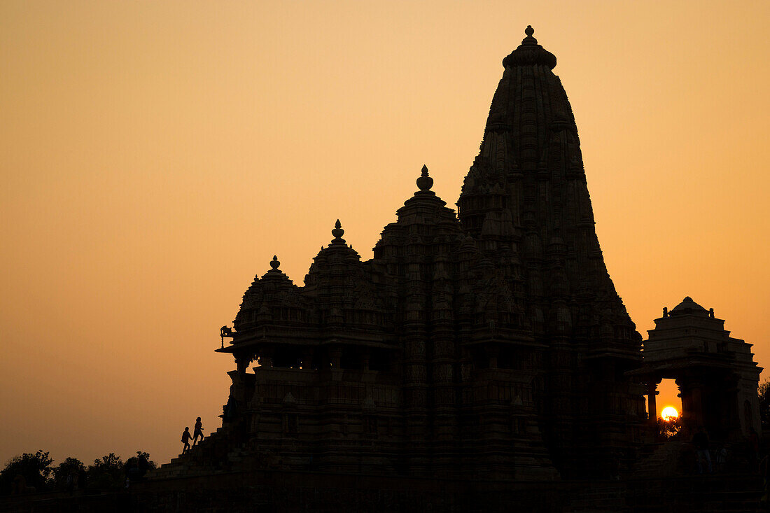 A couple of people ascend a staircase into one of the Lakshmana Temple, a Hindu temple in Khajuraho India.