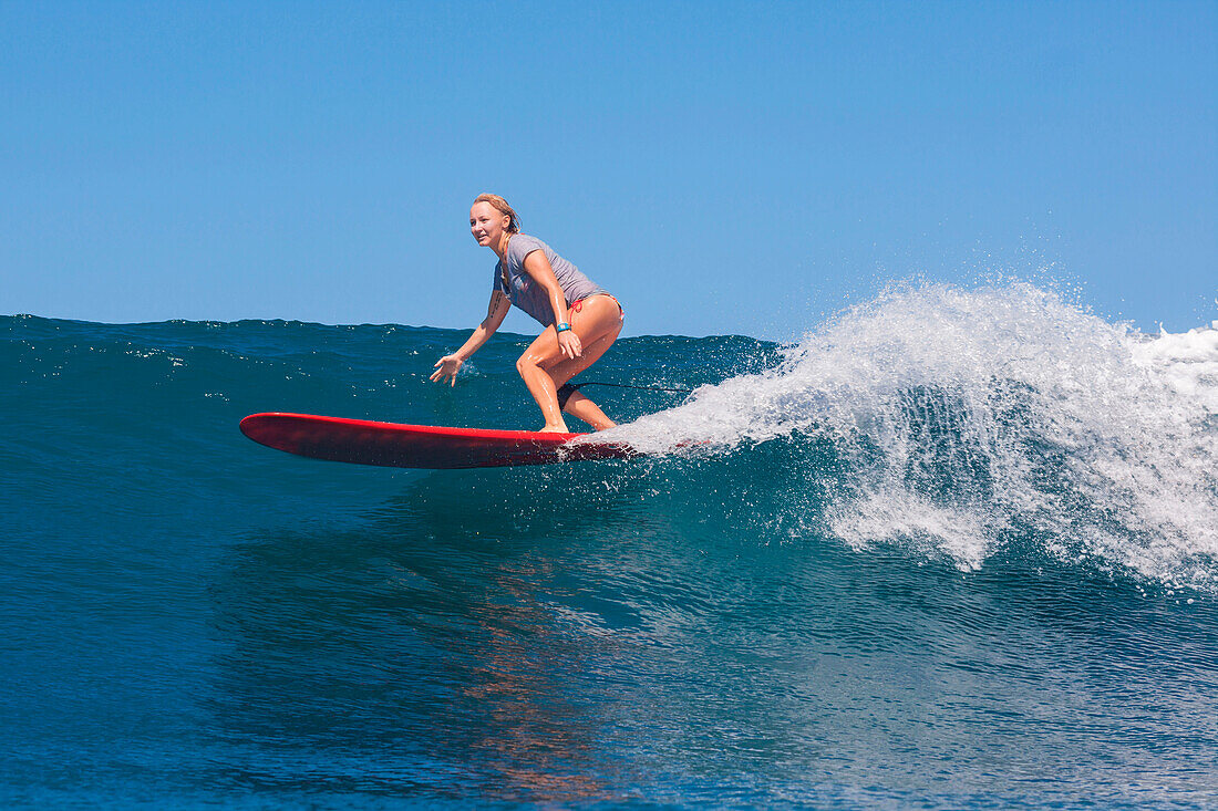 Picture of young woman surfing.