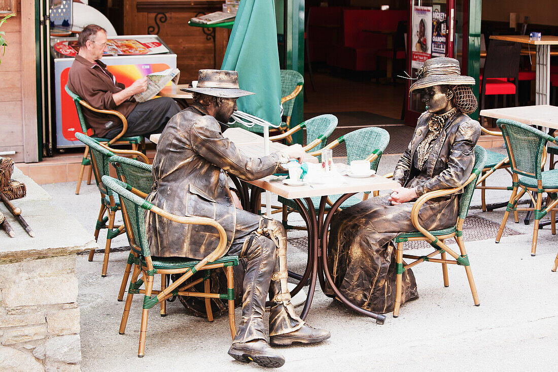 'Stand-still artists dressed as old fashioned mountain climbers having a coffee break in centre of Chamonix-Mont Blanc; Chamonix, Mont Blanc Valley, France'