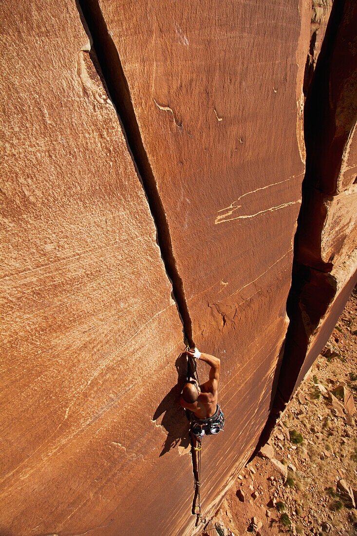 'A rock climber climbing Blue Sun 5.10; Indian Creek, Utah, United States of America'