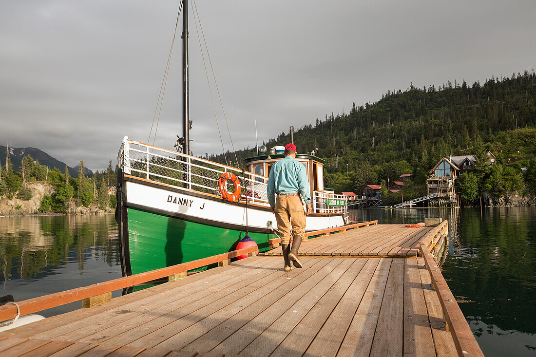 Tourist walking towards the Kachemak Bay Ferry vessel, the Danny J, at Halibut Cove, Southcentral Alaska