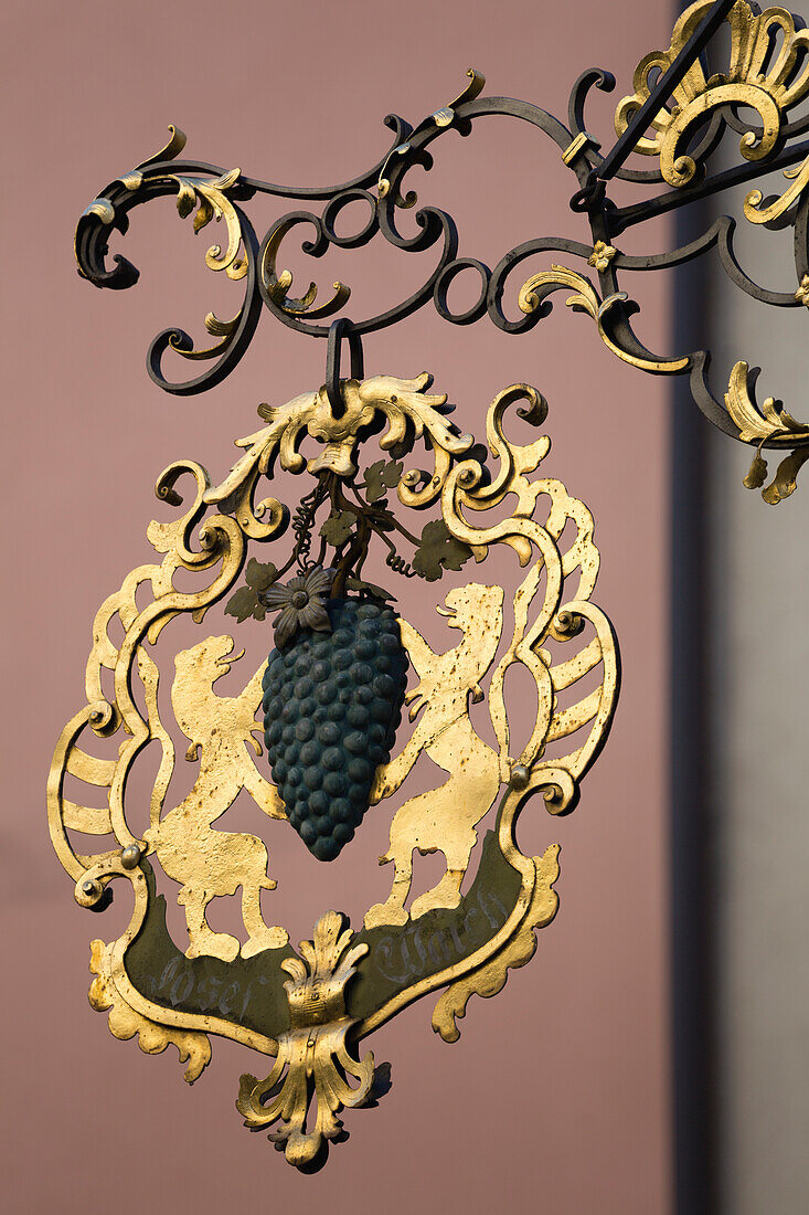 'Close up of gold sign with grapes and lions; Rattenberg, Austria'