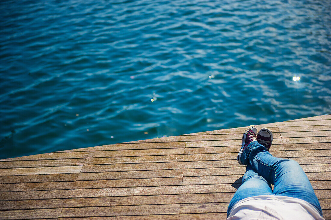 'Laying down on a wooden dock at the water's edge; Barcelona, Spain'