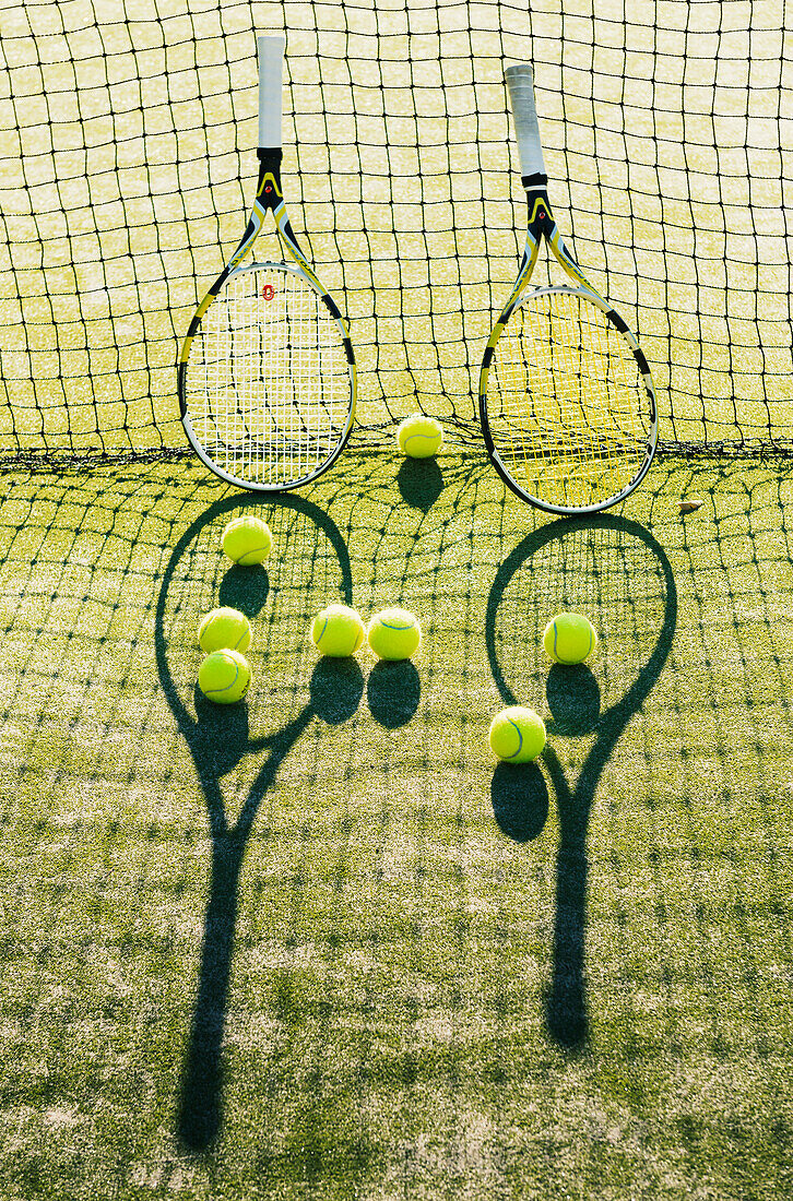'Tennis racquets and balls against a net on the grass; Tarifa, Cadiz, Andalusia, Spain'