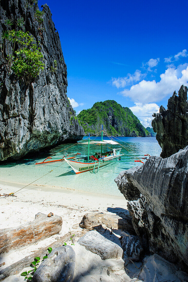 Outrigger boat on a little white beach and crystal clear water in the Bacuit archipelago, Palawan, Philippines, Southeast Asia, Asia