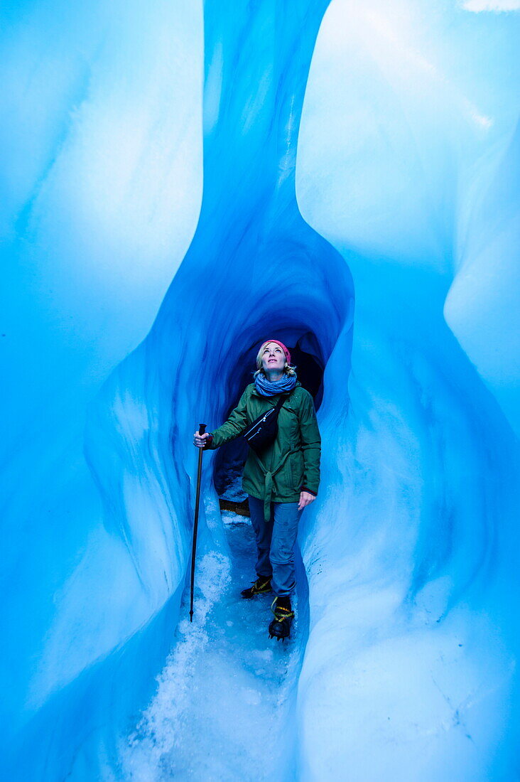 Woman standing in an ice cave, Fox Glacier, Westland Tai Poutini National Park, South Island, New Zealand, Pacific