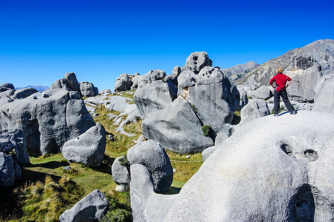 Woman standing on the limestone outcrops of Castle Hill, Canterbury, South Island, New Zealand, Pacific
