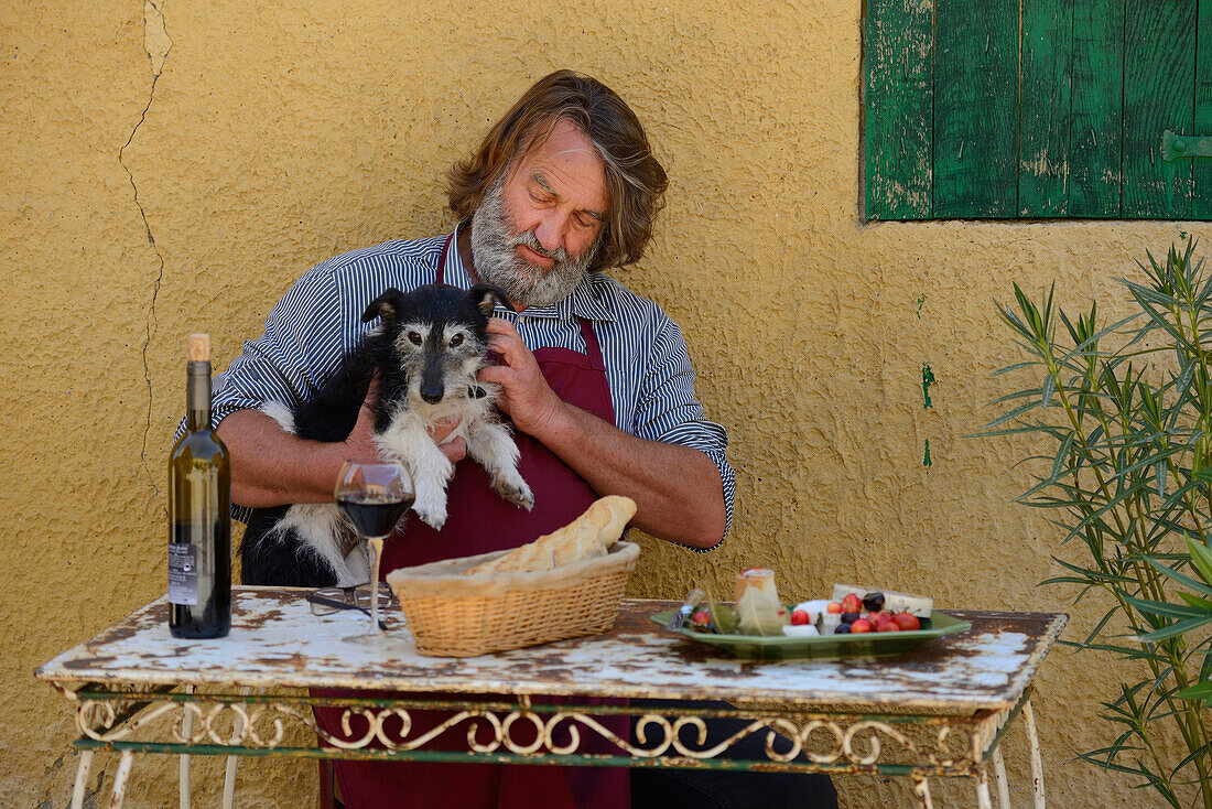 Europe, France, Provence, man, sit, french, table, wine, St. Saturnin les Apt, dog, food, table, fifty