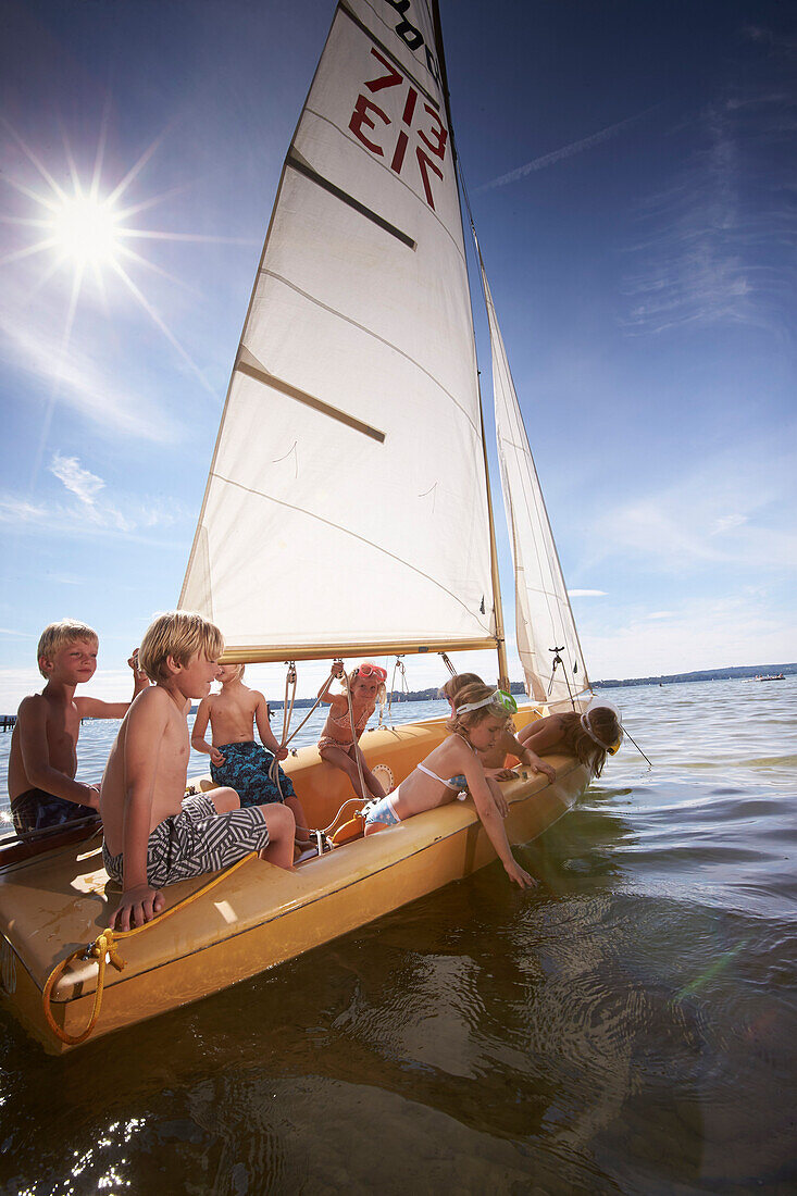 Children in a sailing boat on lake Starnberg, Upper Bavaria, Bavaria, Germany