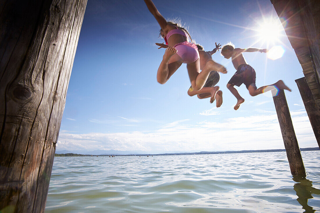 Children jumping into lake Starnberg, Upper Bavaria, Bavaria, Germany