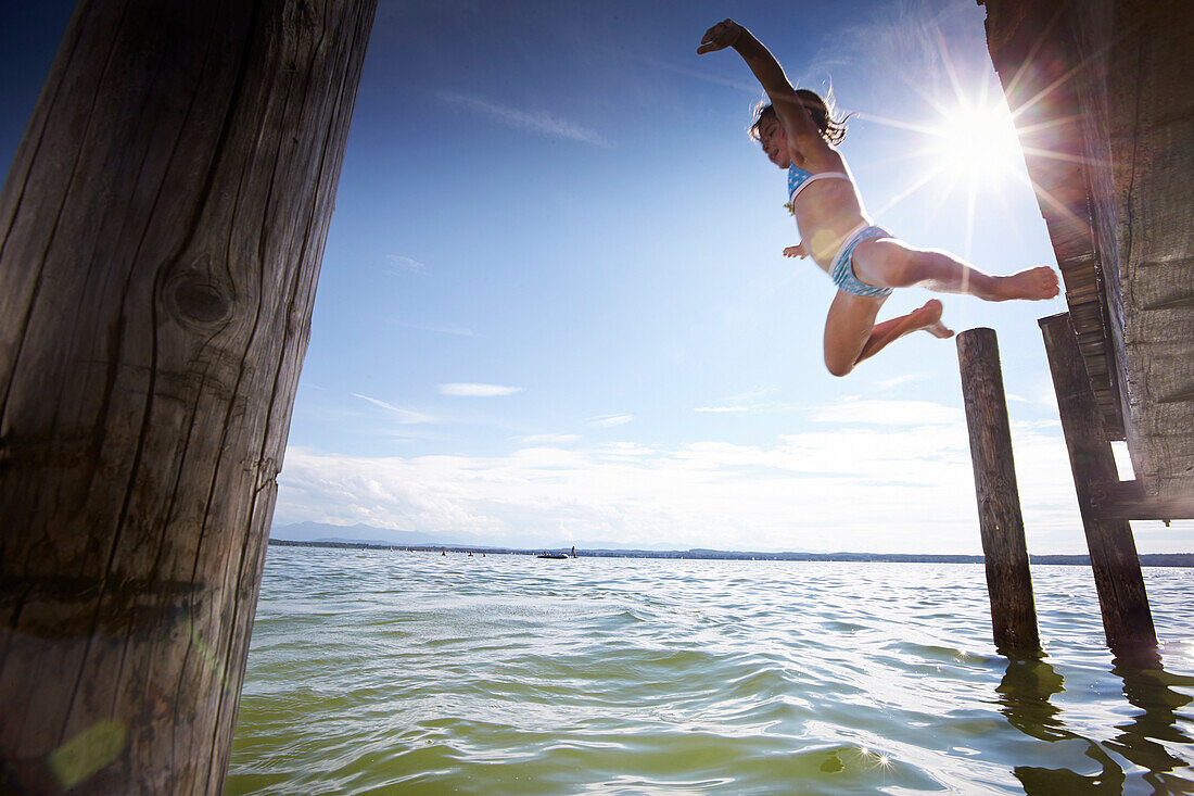 Girl jumping into water, lake Starnberg, Upper Bavaria, Bavaria, Germany