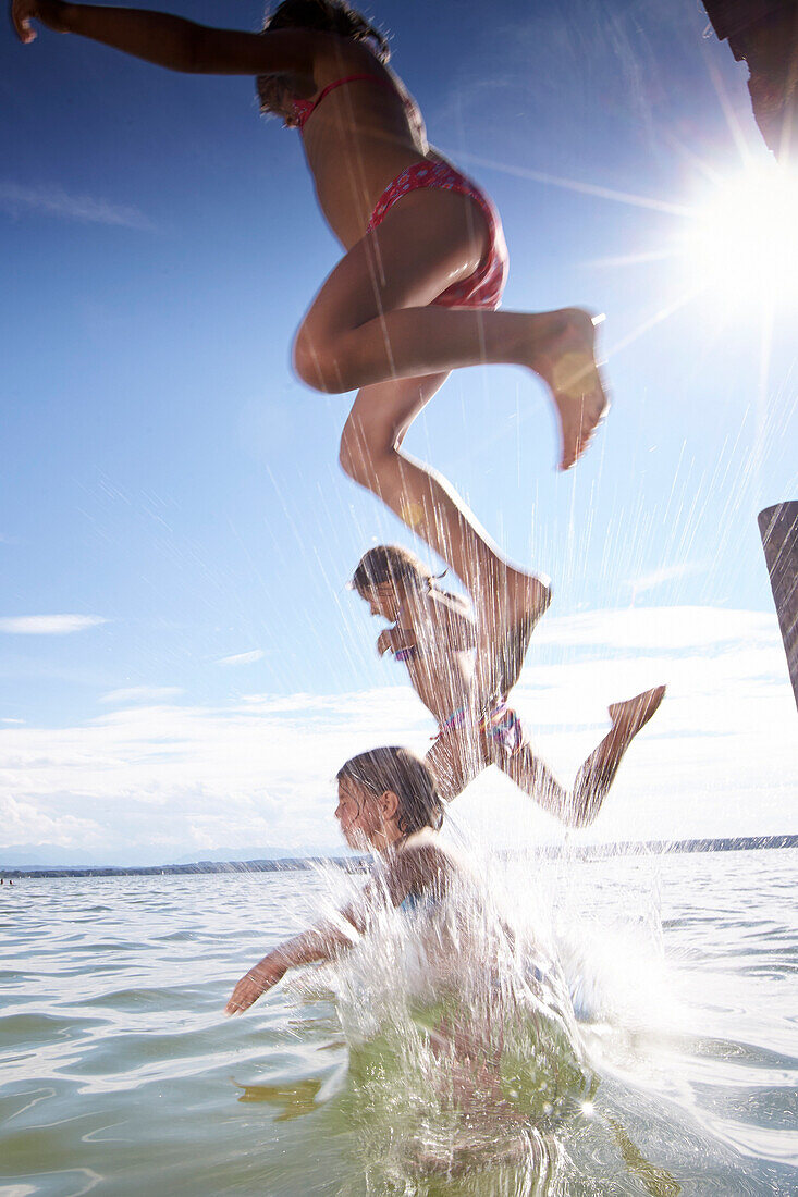 Drei Mädchen springen ins Wasser, Starnberger See, Oberbayern, Bayern, Deutschland