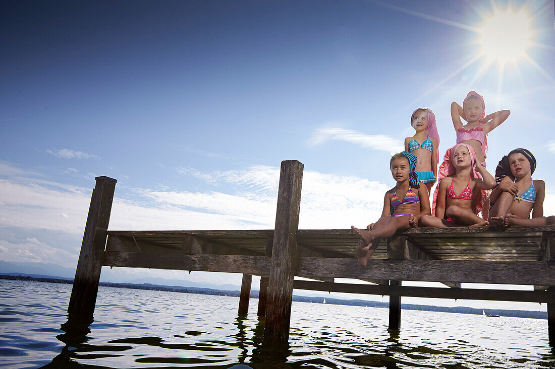 Mädchen mit Handtuchturbanen sitzen auf einem Steg am Starnberger See, Oberbayern, Bayern, Deutschland