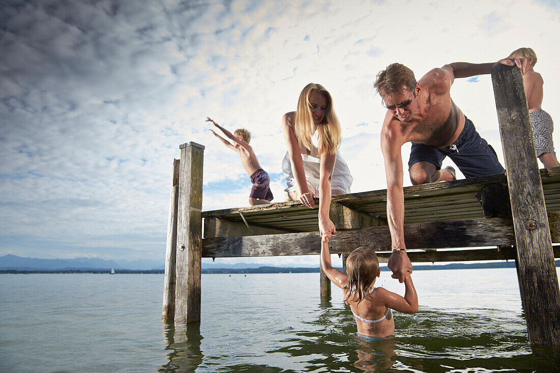 Eltern heben Tochter aus dem Wasser, Starnberger See, Oberbayern, Bayern, Deutschland