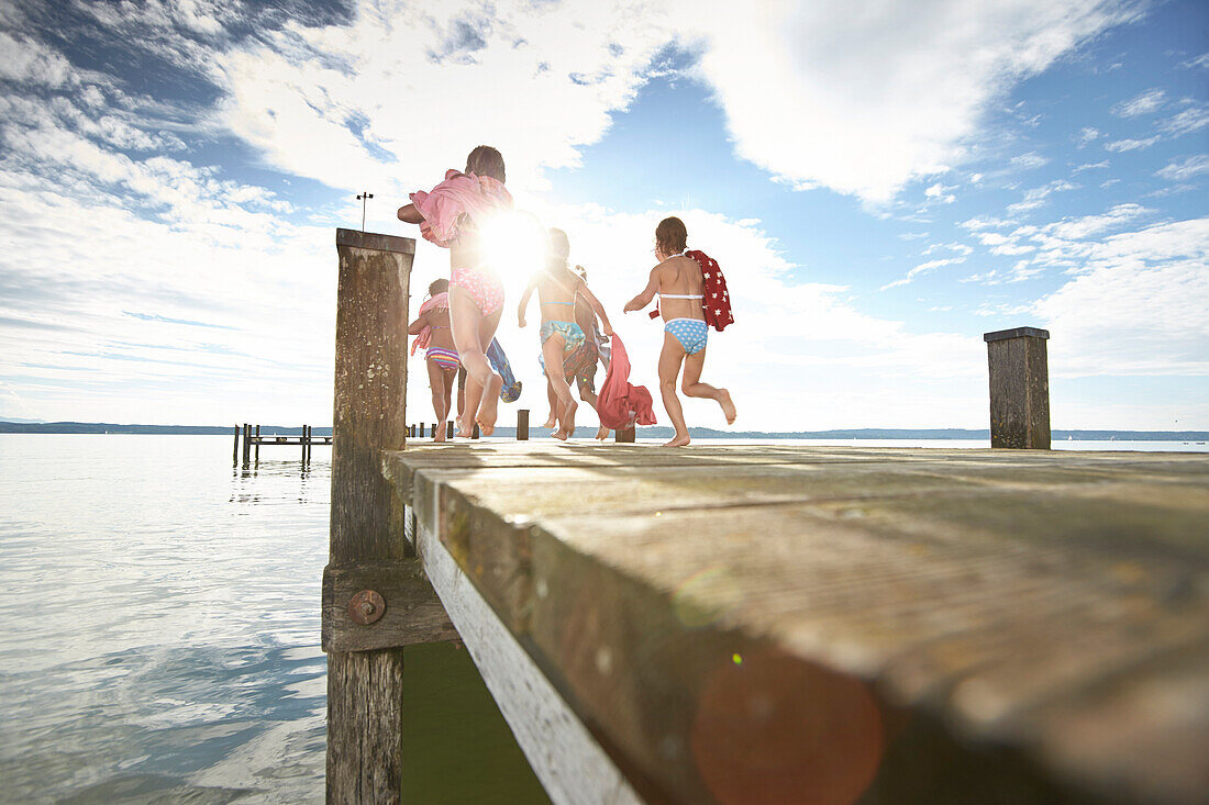 Children running along a jetty, lake Starnberg, Upper Bavaria, Bavaria, Germany