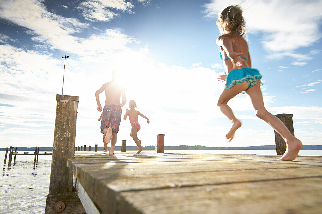 Children running along a jetty, lake Starnberg, Upper Bavaria, Bavaria, Germany