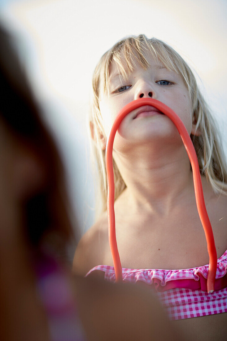 Girl with a fruitgum stick, lake Starnberg, Upper Bavaria, Bavaria, Germany