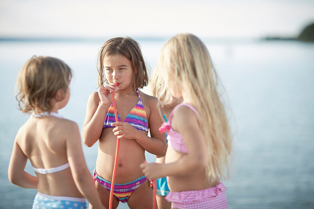 Three girls with fruitgum sticks, lake Starnberg, Upper Bavaria, Bavaria, Germany