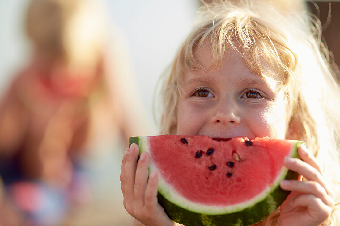 Girl eating a slice of melon, lake Starnberg, Upper Bavaria, Bavaria, Germany