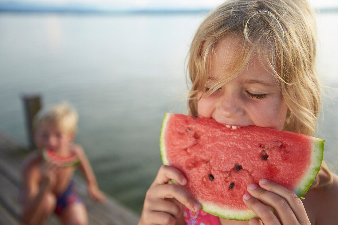 Girl eating a slice of melon, lake Starnberg, Upper Bavaria, Bavaria, Germany