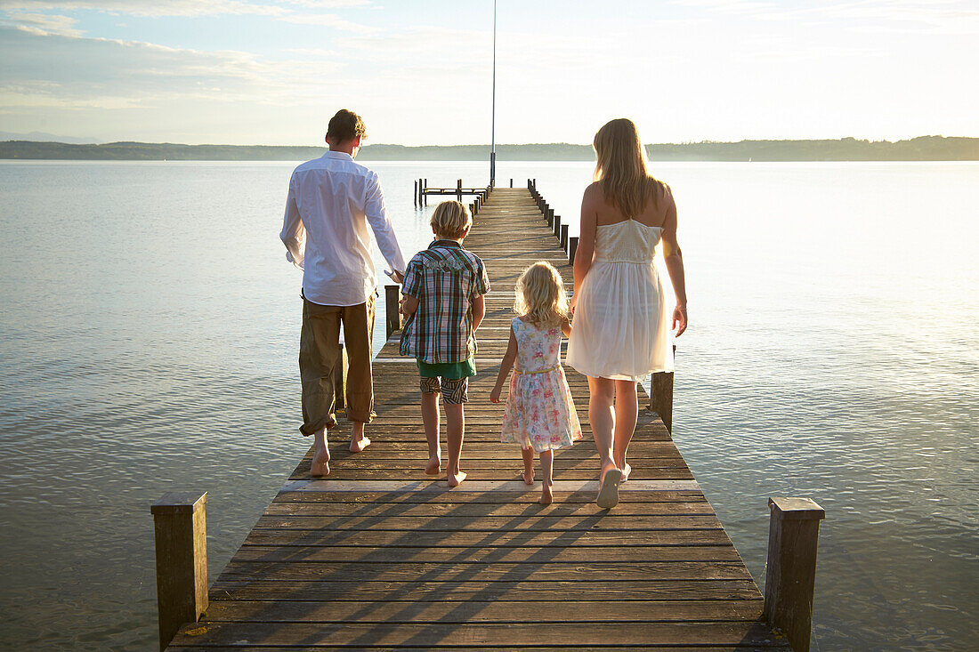 Family on a jetty at lake Starnberg, Upper Bavaria, Bavaria, Germany